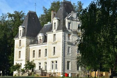 Vue d'un couloir lumineux menant à une chambre avec un lit, des murs clairs et un tapis au sol.