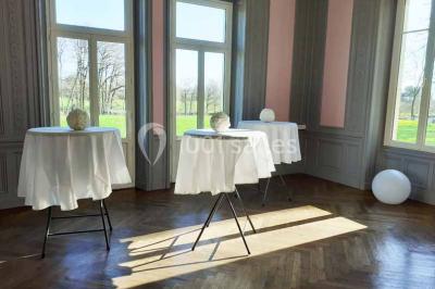 Vue d'un couloir lumineux menant à une chambre avec un lit, des murs clairs et un tapis au sol.