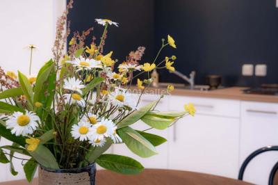 Vue d'un couloir lumineux menant à une chambre avec un lit, des murs clairs et un tapis au sol.