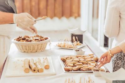 Kiosque décoré de fleurs blanches au bord d'un lac avec une fontaine, sous un ciel dégagé.