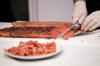 Kiosque décoré de fleurs blanches au bord d'un lac avec une fontaine, sous un ciel dégagé.