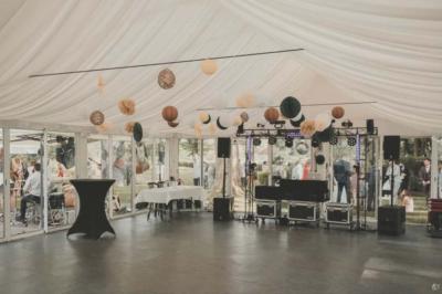 Kiosque décoré de fleurs blanches au bord d'un lac avec une fontaine, sous un ciel dégagé.
