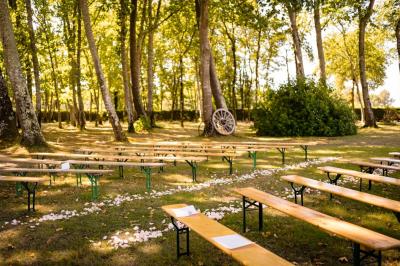 Kiosque décoré de fleurs blanches au bord d'un lac avec une fontaine, sous un ciel dégagé.