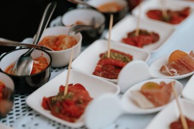 Kiosque décoré de fleurs blanches au bord d'un lac avec une fontaine, sous un ciel dégagé.