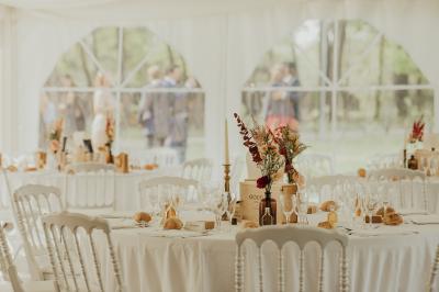 Kiosque décoré de fleurs blanches au bord d'un lac avec une fontaine, sous un ciel dégagé.