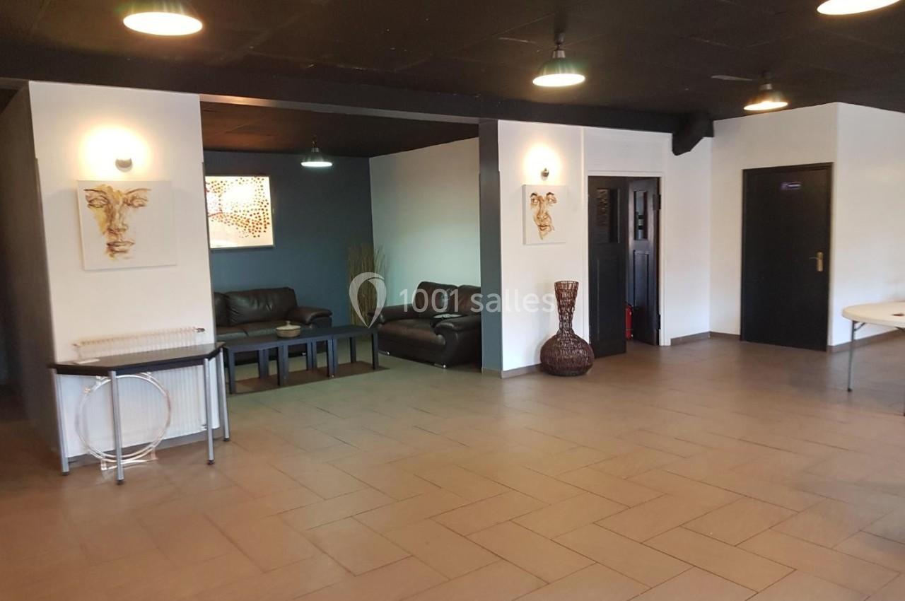 Salle avec un sol carrelé, des canapés en cuir, des décorations murales et un éclairage suspendu.