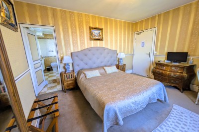 Miniature Location salle Quesmy (Oise) - Château de Quesmy #18 Chambre élégante avec murs bleus, lit double, cheminée, miroir doré, armoire en bois et tapis géométrique.
