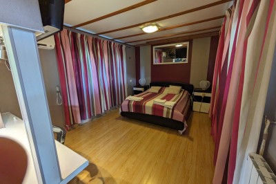 Miniature Location salle Quesmy (Oise) - Château de Quesmy #29 Chambre élégante avec murs bleus, lit double, cheminée, miroir doré, armoire en bois et tapis géométrique.