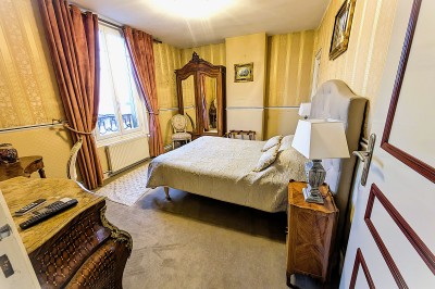 Miniature Location salle Quesmy (Oise) - Château de Quesmy #40 Chambre élégante avec murs bleus, lit double, cheminée, miroir doré, armoire en bois et tapis géométrique.