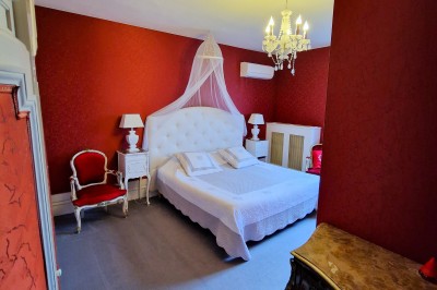 Miniature Location salle Quesmy (Oise) - Château de Quesmy #43 Chambre élégante avec murs bleus, lit double, cheminée, miroir doré, armoire en bois et tapis géométrique.