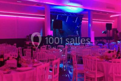 Miniature Location salle Le Raincy (Seine-Saint-Denis) - Le Chalet des Pins #7 Scène de DJ éclairée par des lumières colorées, entourée de rideaux rouges et de haut-parleurs dans une salle.