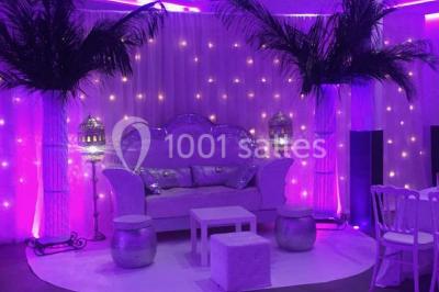 Miniature Location salle Le Raincy (Seine-Saint-Denis) - Le Chalet des Pins #11 Scène de DJ éclairée par des lumières colorées, entourée de rideaux rouges et de haut-parleurs dans une salle.