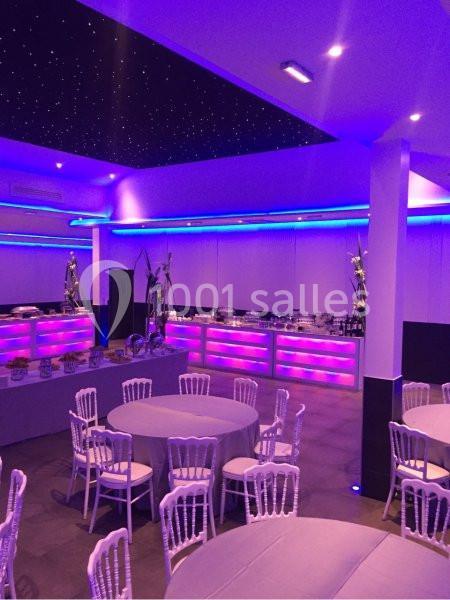 Location salle Le Raincy (Seine-Saint-Denis) - Le Chalet des Pins #19 Salle de réception avec tables rondes, chaises blanches et éclairage violet, plafond étoilé en arrière-plan.