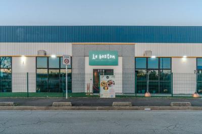 Miniature Location salle Villeneuve-le-Roi (Val-de-Marne) - Le Boston #11 Salle intérieure avec terrain de sport entouré de filets, tables et chaises disposées sur un sol en gazon synthétique.