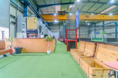 Miniature Location salle Villeneuve-le-Roi (Val-de-Marne) - Le Boston #13 Salle intérieure avec terrain de sport entouré de filets, tables et chaises disposées sur un sol en gazon synthétique.