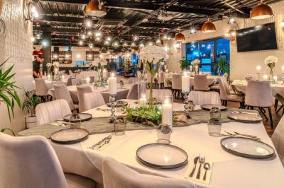 Miniature Location salle Villeneuve-le-Roi (Val-de-Marne) - Le Boston #3 Salle intérieure avec terrain de sport entouré de filets, tables et chaises disposées sur un sol en gazon synthétique.