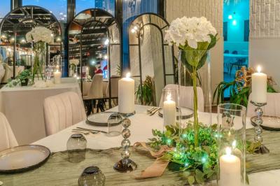 Miniature Location salle Villeneuve-le-Roi (Val-de-Marne) - Le Boston #7 Salle intérieure avec terrain de sport entouré de filets, tables et chaises disposées sur un sol en gazon synthétique.