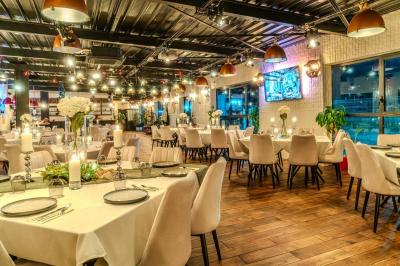 Miniature Location salle Villeneuve-le-Roi (Val-de-Marne) - Le Boston #2 Salle intérieure avec terrain de sport entouré de filets, tables et chaises disposées sur un sol en gazon synthétique.