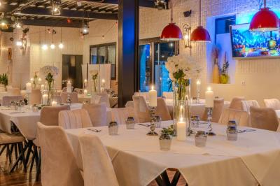 Miniature Location salle Villeneuve-le-Roi (Val-de-Marne) - Le Boston #8 Salle intérieure avec terrain de sport entouré de filets, tables et chaises disposées sur un sol en gazon synthétique.