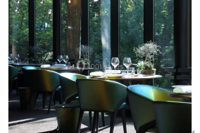 Un public assis dans une salle de conférence, attentif à une présentation sur une scène éclairée.