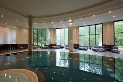 Un public assis dans une salle de conférence, attentif à une présentation sur une scène éclairée.