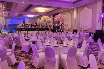 Un public assis dans une salle de conférence, attentif à une présentation sur une scène éclairée.