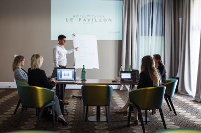 Un public assis dans une salle de conférence, attentif à une présentation sur une scène éclairée.