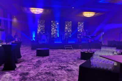 Un public assis dans une salle de conférence, attentif à une présentation sur une scène éclairée.