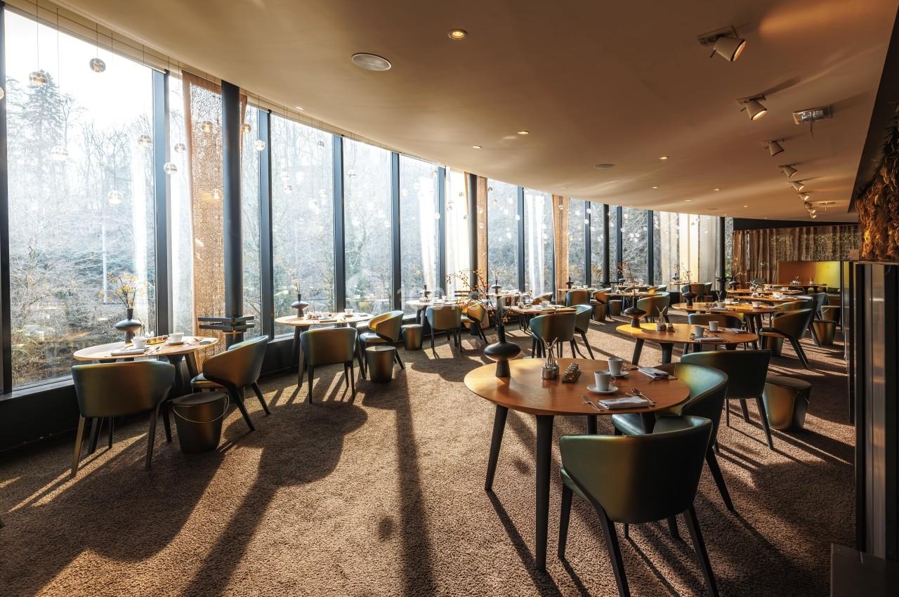 Location salle La Tour-de-Salvagny (Rhône) - Le Pasino Grand et l'Hôtel & Spa Le Pavillon #6 Salle de restaurant lumineuse avec de grandes baies vitrées, tables en bois et chaises modernes.