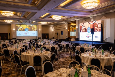 Des personnes jouent à la pétanque sur un terrain en plein air, entouré de verdure.