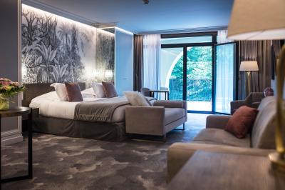 Des personnes jouent à la pétanque sur un terrain en plein air, entouré de verdure.