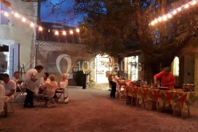 Miniature Location salle Caderousse (Vaucluse) - Domaine de la Lusignane #10 Salle décorée pour un événement, avec des tables alignées, nappes blanches, chemins de table rouges et lanternes suspendues.
