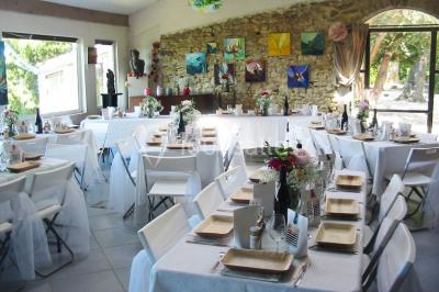 Miniature Location salle Caderousse (Vaucluse) - Domaine de la Lusignane #2 Salle décorée pour un événement, avec des tables alignées, nappes blanches, chemins de table rouges et lanternes suspendues.