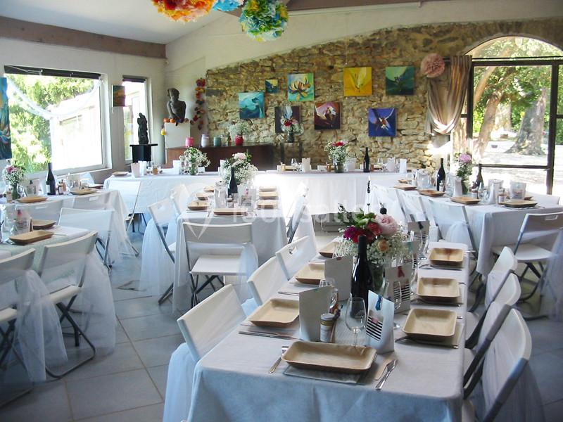 Location salle Caderousse (Vaucluse) - Domaine de la Lusignane #2 Salle décorée pour un événement, avec des tables dressées, nappes blanches et arrangements floraux colorés.