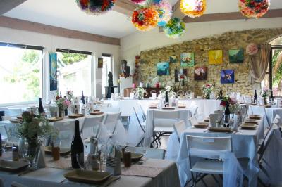 Miniature Location salle Caderousse (Vaucluse) - Domaine de la Lusignane #3 Salle décorée pour un événement, avec des tables alignées, nappes blanches, chemins de table rouges et lanternes suspendues.