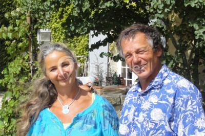 Miniature Location salle Caderousse (Vaucluse) - Domaine de la Lusignane #4 Salle décorée pour un événement, avec des tables alignées, nappes blanches, chemins de table rouges et lanternes suspendues.