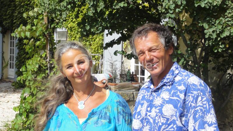Location salle Caderousse (Vaucluse) - Domaine de la Lusignane #4 Un homme et une femme sourient devant une maison entourée de végétation.