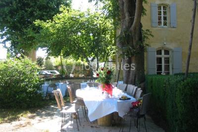 Miniature Location salle Caderousse (Vaucluse) - Domaine de la Lusignane #13 Salle décorée pour un événement, avec des tables alignées, nappes blanches, chemins de table rouges et lanternes suspendues.