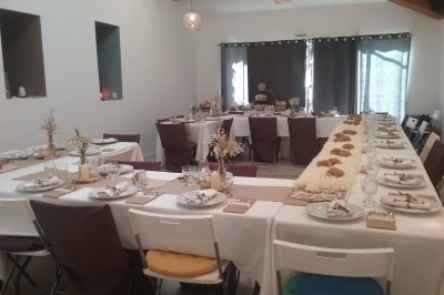 Miniature Location salle Caderousse (Vaucluse) - Domaine de la Lusignane #18 Salle décorée pour un événement, avec des tables alignées, nappes blanches, chemins de table rouges et lanternes suspendues.