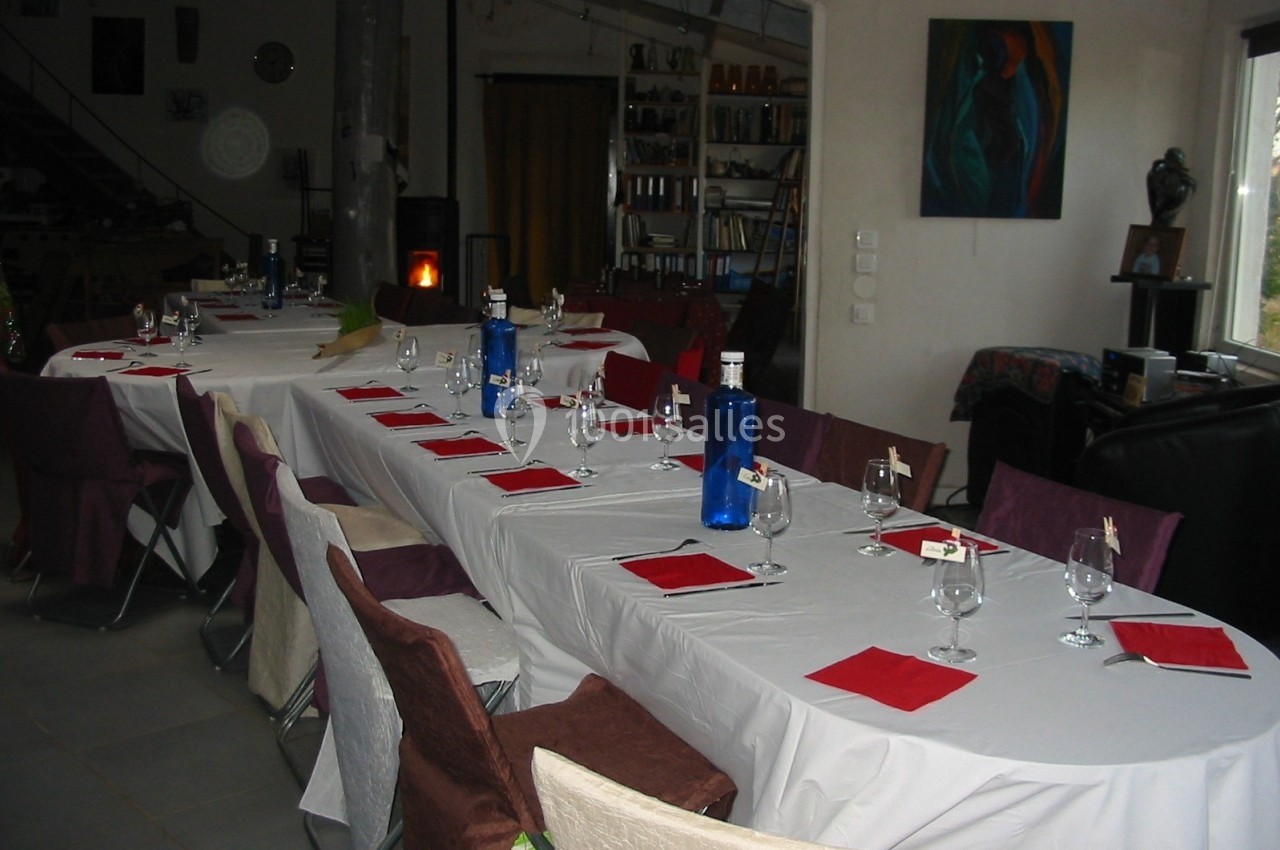 Location salle Caderousse (Vaucluse) - Domaine de la Lusignane #19 Tables dressées avec nappes blanches, serviettes rouges, verres et bouteilles bleues dans une salle conviviale.