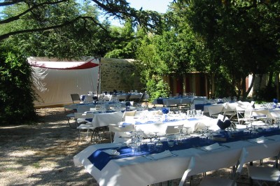 Miniature Location salle Caderousse (Vaucluse) - Domaine de la Lusignane #20 Salle décorée pour un événement, avec des tables alignées, nappes blanches, chemins de table rouges et lanternes suspendues.
