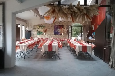 Miniature Location salle Caderousse (Vaucluse) - Domaine de la Lusignane #25 Salle décorée pour un événement, avec des tables alignées, nappes blanches, chemins de table rouges et lanternes suspendues.