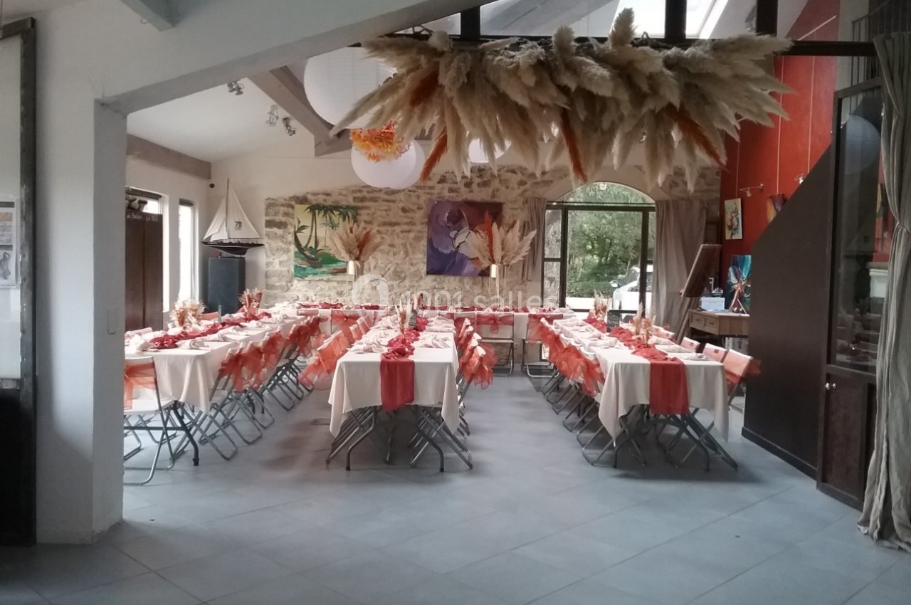 Location salle Caderousse (Vaucluse) - Domaine de la Lusignane #25 Salle décorée pour un événement avec tables alignées, nappes blanches et chemins de table orange, dans un cadre lumineux.