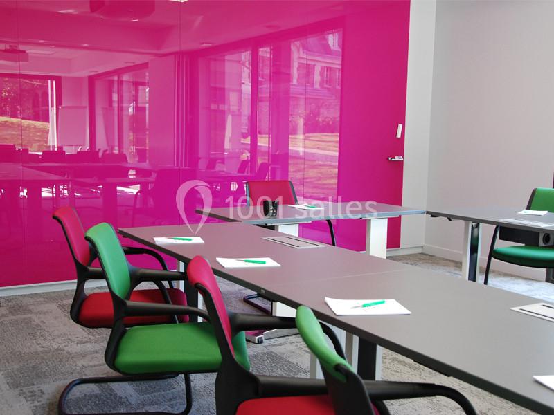 Location salle Louveciennes (Yvelines) - Campus BNP Paribas Louveciennes #4 Salle de réunion moderne avec murs roses, tables grises, chaises colorées et documents posés sur les tables.