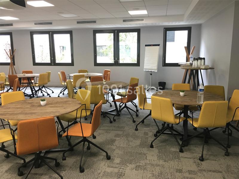 Location salle Louveciennes (Yvelines) - Campus BNP Paribas Louveciennes #11 Salle de réunion lumineuse avec tables rondes en bois, chaises colorées et tableau de présentation.