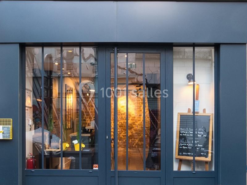 Location salle Paris 11 (Paris) - Les Rendez-vous #10 Façade d'un restaurant avec une porte vitrée, un tableau noir affichant le menu et un intérieur éclairé visible.