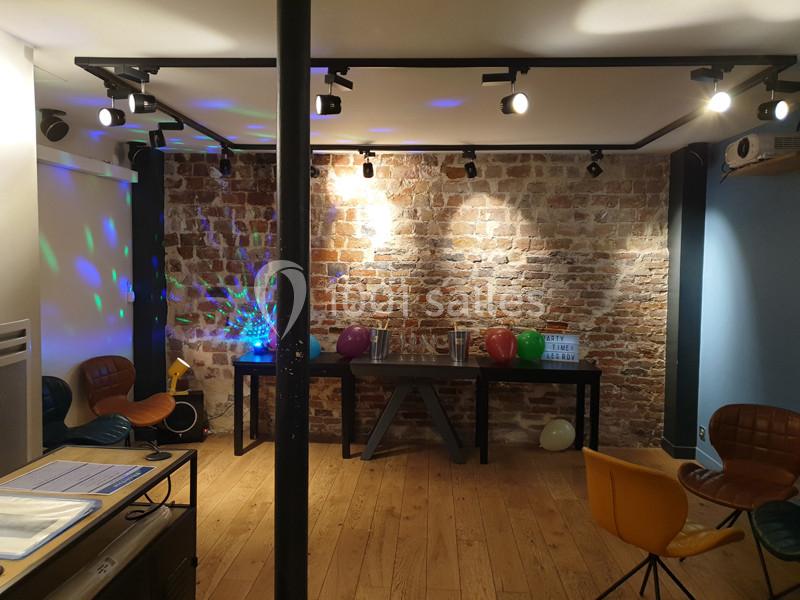 Location salle Paris 11 (Paris) - Les Rendez-vous #2 Salle avec mur en briques, parquet, chaises colorées, ballons et éclairage décoratif.