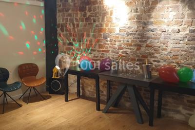 Miniature Location salle Paris 11 (Paris) - Les Rendez-vous #5 Salle de réunion moderne avec table noire, chaises, écran de projection, paperboard et cuisine ouverte en arrière-plan.