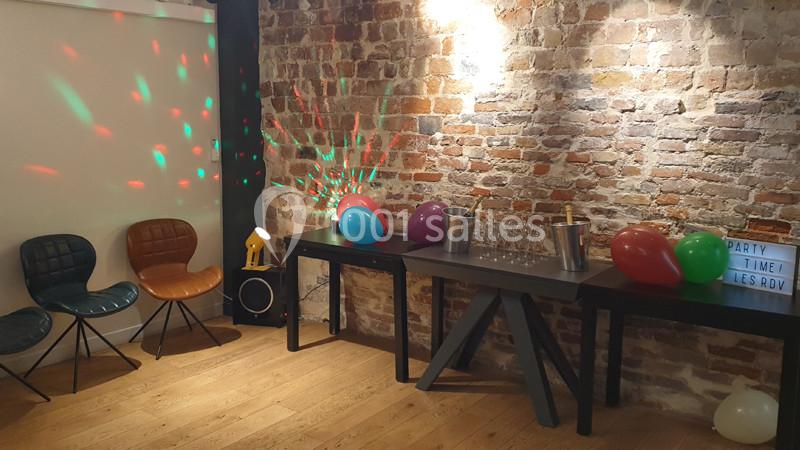 Location salle Paris 11 (Paris) - Les Rendez-vous #5 Salle décorée pour une fête avec des ballons colorés, des tables garnies de verres et un mur en briques apparentes.