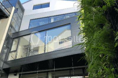 Mur végétal avec plantes vertes en arrière-plan, deux femmes assises, l'une travaillant sur un ordinateur portable.